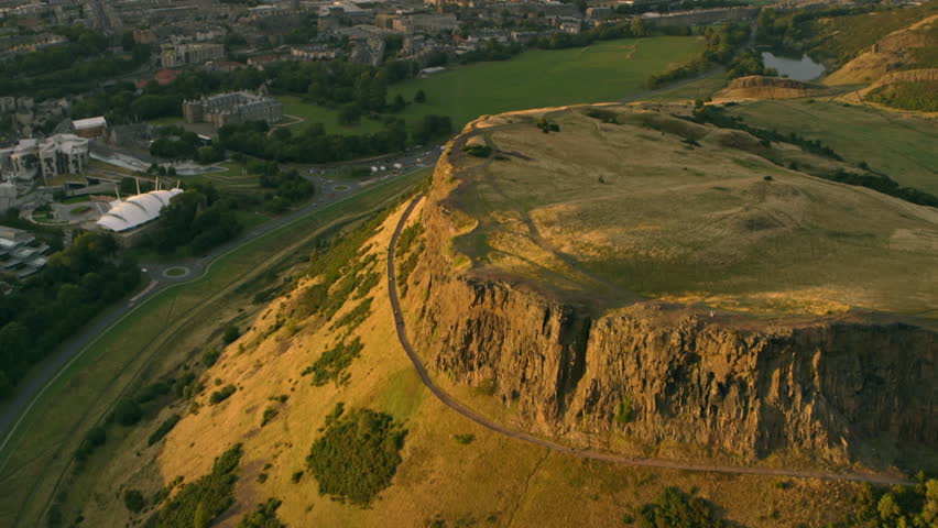 Stunning aerial perspective of Salisbury Crags and Holyrood Park during a beautiful summer sunset