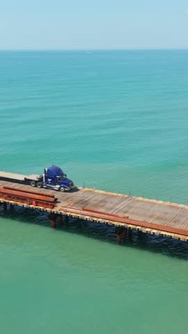 Vertical screen. Truck parked on wooden pier over turquoise water, showcasing the serene coastal landscape of Myrtle Beach, South Carolina, USA
