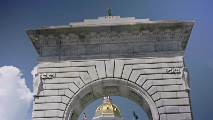 Cinematic tilt down shot of the Soldiers and Sailors Memorial Arch on the grounds of the New Hampshire State House in Concord New Hampshire during a sunny summer day.