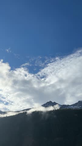 Forest and Clouds Over Mountain Slopes in Alaska Landscape

Video of clouds and fog over forest and mountain slopes with blue sky in Alaska. Nature landscape with trees and mountains.
