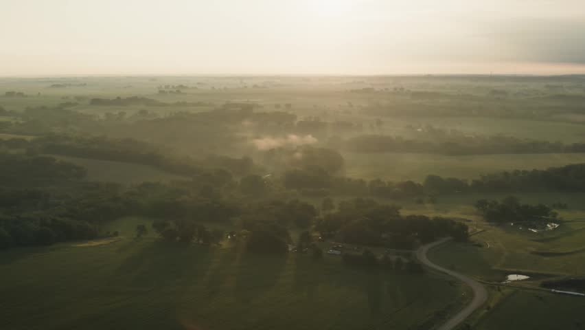 A foggy sunrise over rural Iowa land.
