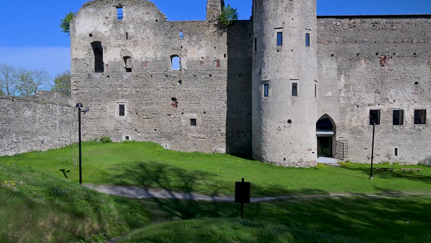 Ancient stone walls and the clock tower of the Haapsalu Episcopal Castle. Famous historical landmark and tourist destination in Estonia