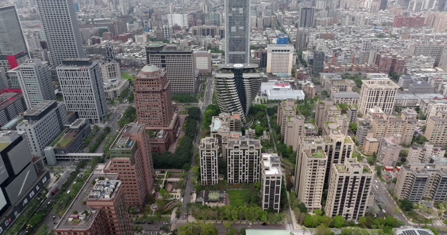 Aerial view of Taipei, the vibrant capital city of Taiwan, showing streets and modern skyscrapers in the Xinyi District during daytime. 