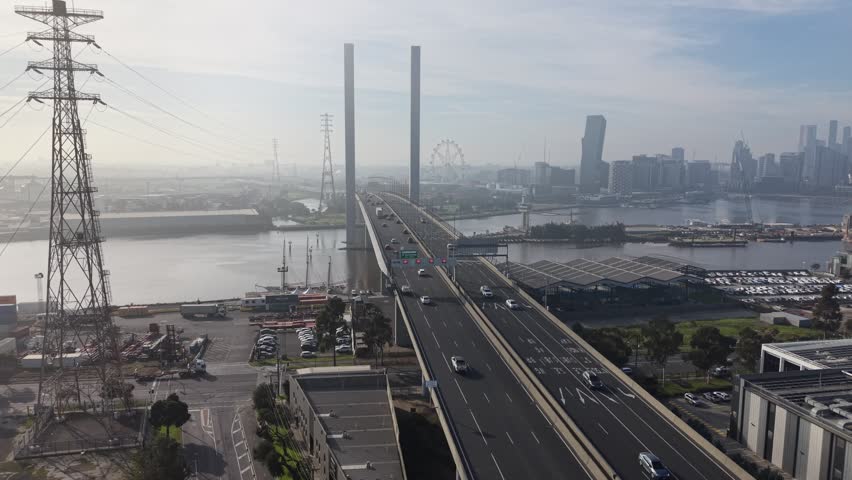 Aerial rising view approaching Bolte Bridge with Melbourne skyline and Docklands over the Yarra River, Victoria, Australia