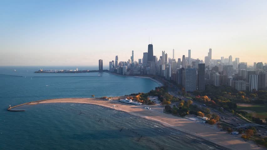 An Aerial view of North Avenue Beach curving into Lake Michigan beside downtown Chicago skyline