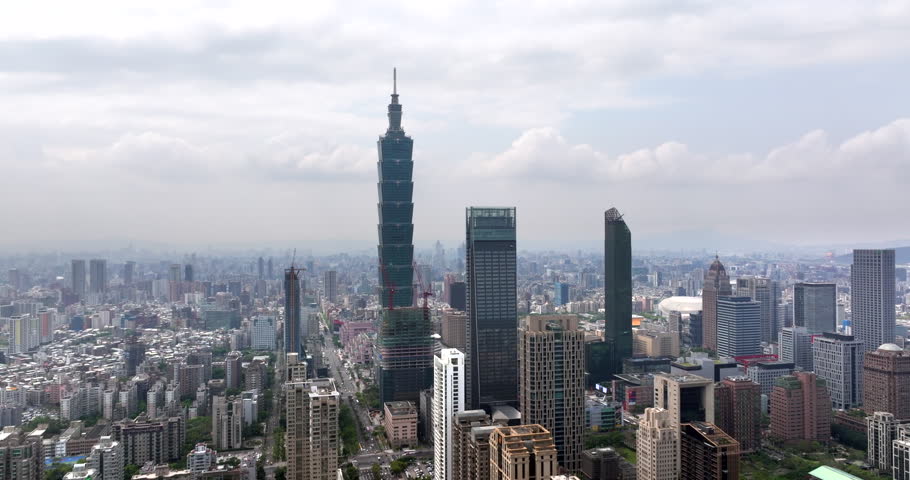 Aerial view of Taipei, the vibrant capital city of Taiwan, with the iconic Taipei 101 tower and other skyscrapers in the Xinyi Commercial District on a sunny day.