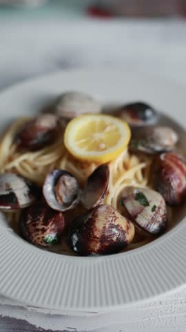 A tempting close-up of spaghetti served with fresh seafood and clams. The pasta is perfectly cooked and mixed with delicious shellfish in a savory sauce. Ideal for Italian seafood cuisine and Mediterranean food photography.