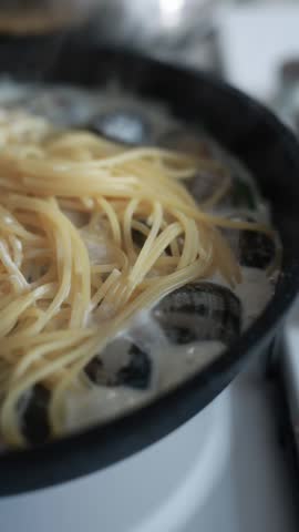 A tempting close-up of spaghetti served with fresh seafood and clams. The pasta is perfectly cooked and mixed with delicious shellfish in a savory sauce. Ideal for Italian seafood cuisine and Mediterranean food photography.
