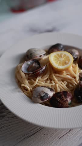 A tempting close-up of spaghetti served with fresh seafood and clams. The pasta is perfectly cooked and mixed with delicious shellfish in a savory sauce. Ideal for Italian seafood cuisine and Mediterranean food photography.