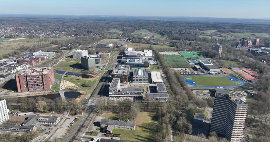 A drone view of Wageningen university and research surrounded by fields on a sunny day in Wageningen, Netherlands