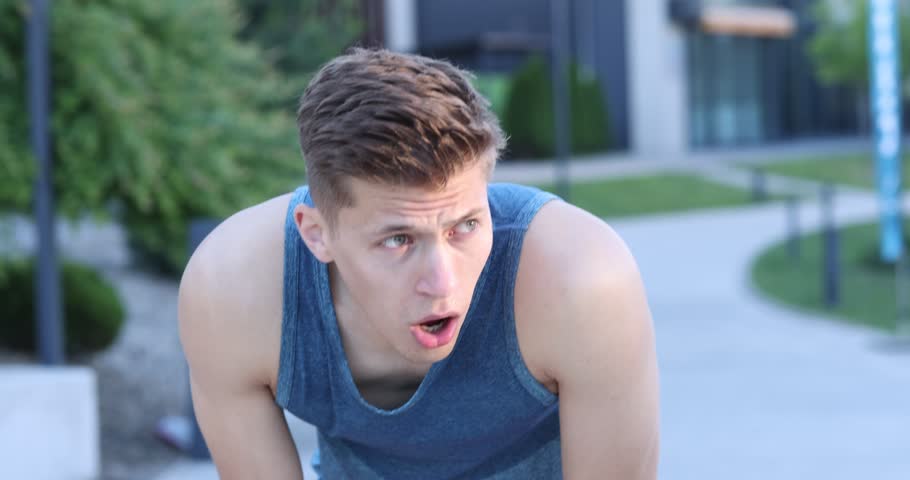 Athletic man with sweat on his body outdoors, camera moving in