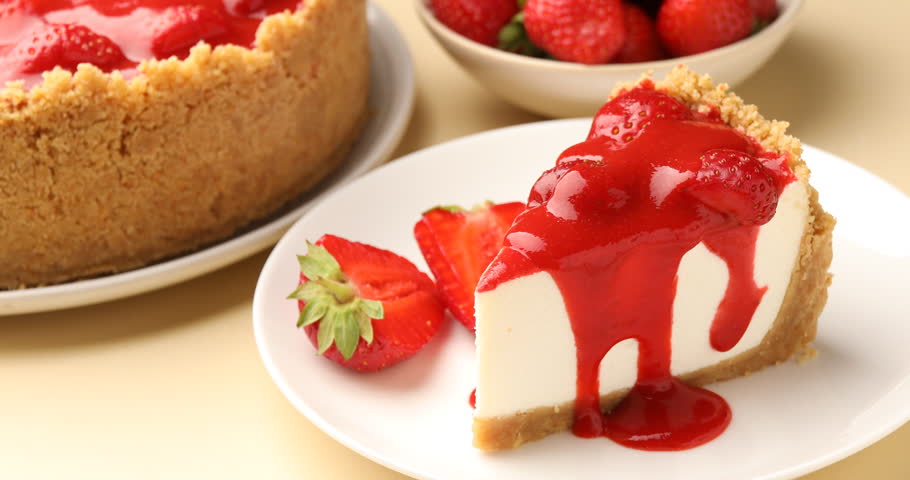 Woman eating piece of tasty cheesecake with strawberries at beige table, closeup