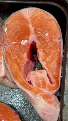Chilled chum salmon steaks from frozen raw materials on a substrate for sale in a supermarket. Close-up