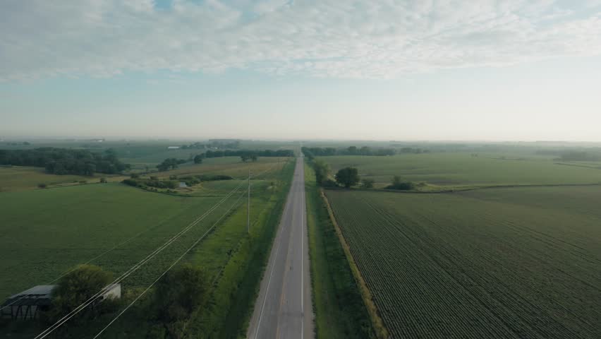 Wide aerial shot of a road running through rural Iowa.
