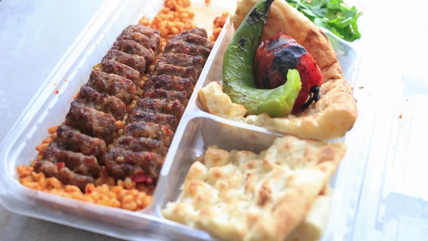 Close-up of traditional Turkish Adana kebab served with grilled vegetables