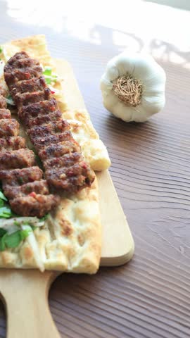 Close-up of traditional Turkish Adana kebab served with grilled vegetables