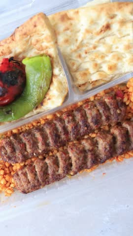 Close-up of traditional Turkish Adana kebab served with grilled vegetables