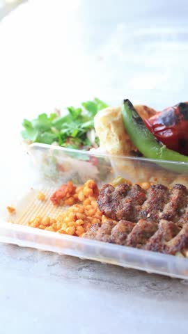 Close-up of traditional Turkish Adana kebab served with grilled vegetables