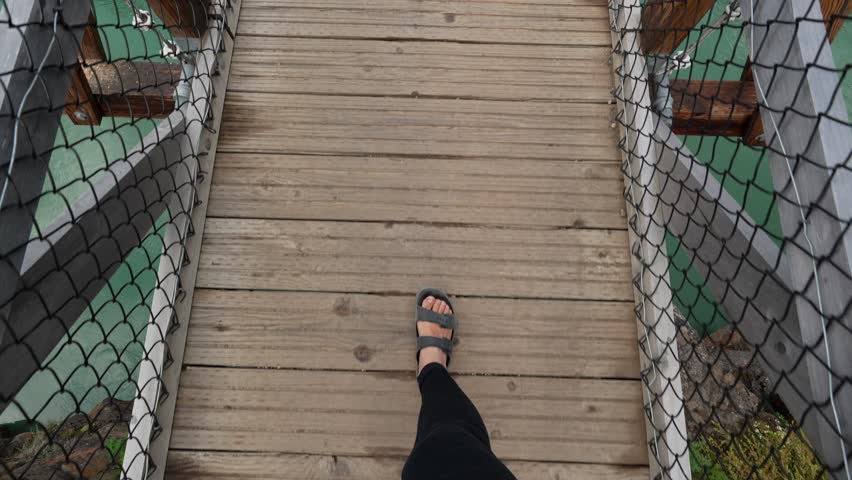Woman walking on Miles Canyon suspension bridge in Yukon, Canada