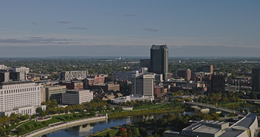 Columbus Ohio Aerial v14 cinematic drone flyover COSI building capturing views of Scioto river and riverfront downtown cityscape against blue cloudless sky - Shot with 8k camera