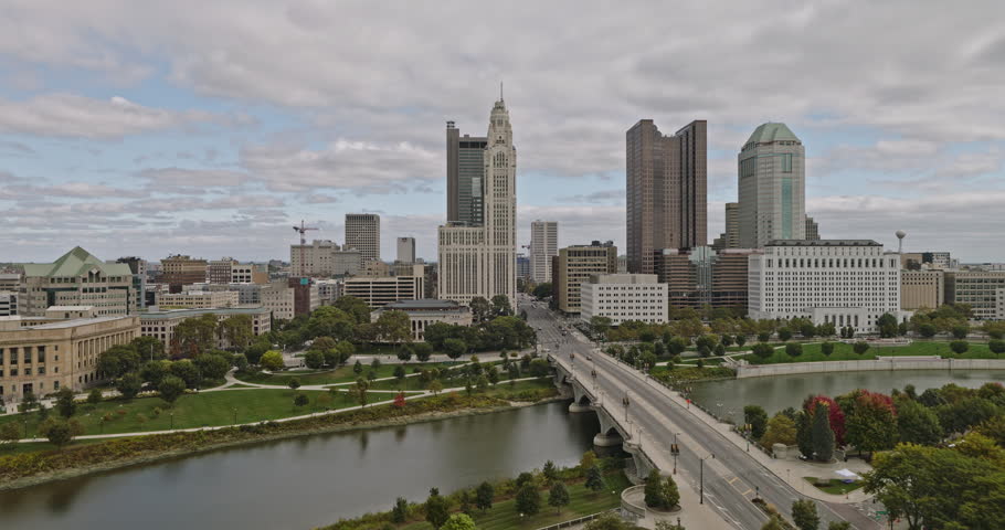 Columbus Ohio Aerial v48 low drone flyover Scioto River along Discovery bridge capturing Battelle riverfront park, city council building, downtown cityscape - Shot with 8k camera