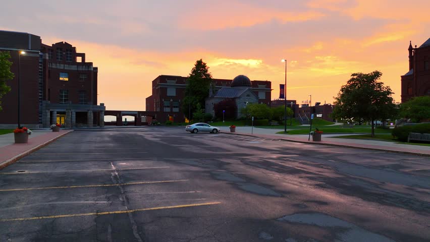 The orange glow of dusk blankets the sky overlooking the city skyline.
