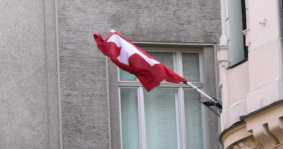 The Swiss flag flutters in the wind in the city.