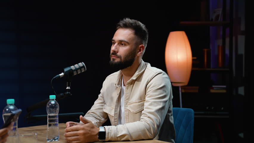 Charismatic man speaking into a microphone during podcast interview