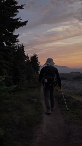 Adventurous Hiker Walks Along Mountain Trail at Sunset in British Columbia, Canada