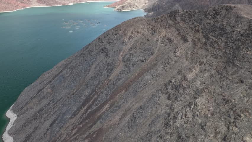 Orto-Tokoy Reservoir in Naryn province in Kyrgyzstan. Aerial drone over the hill to the lake.