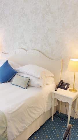 POV on luxury hotel suite bedroom with large king size bed and fancy stylish design and decor. Travel business trip or honeymoon vacation and holiday. Vertical video UGC style by social media vlogger