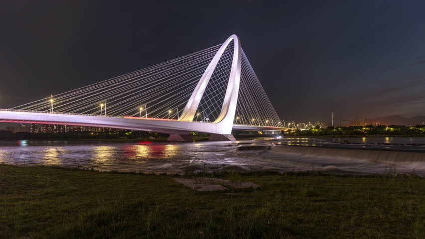 Night view of the new Shougang Bridge in Beijing, China, a city landmark in blue time-lapse mode.