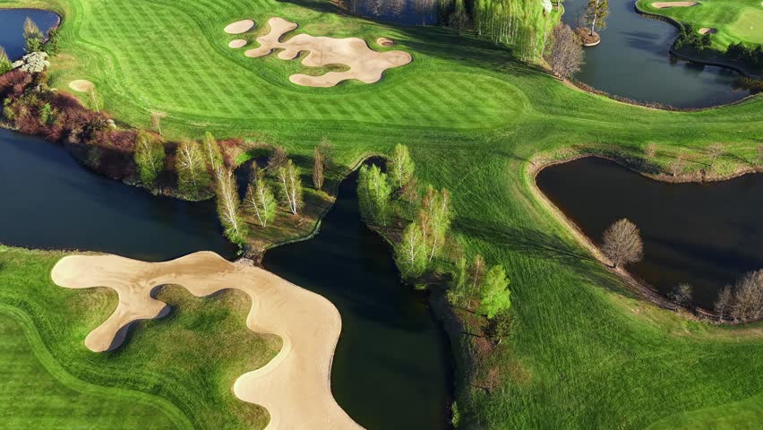 Large golf course with lakes and lush forest nearby