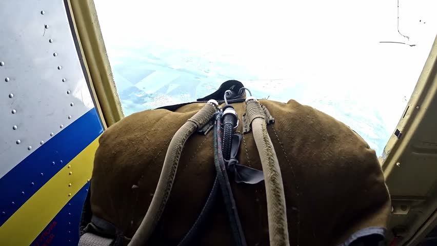 The parachutist falls out of the plane.  An action camera view from a high altitude on a clear day.