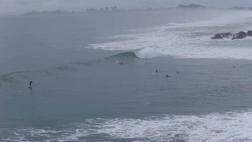 Surfers Riding Waves Near Boulders at Currumbin Beach Gold Coast – Aerial Shot