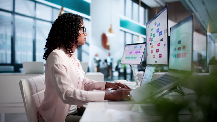 Project Manager Reviews Visual Strategy Diagram Using Laptop And Desktop.