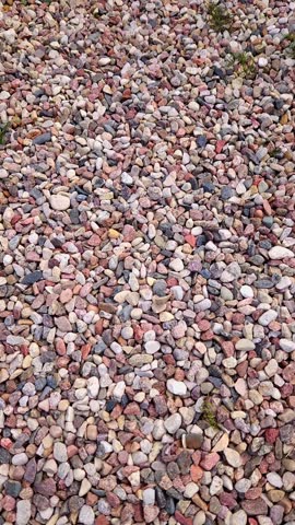 Sound of footsteps on backyard path covered with small colourful pebbles cover ground in outdoor space