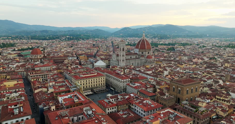 Florence high angle aerial panorama historic architecture duomo cathedral square red roofs misty mountains background cloudy day travel Italy.