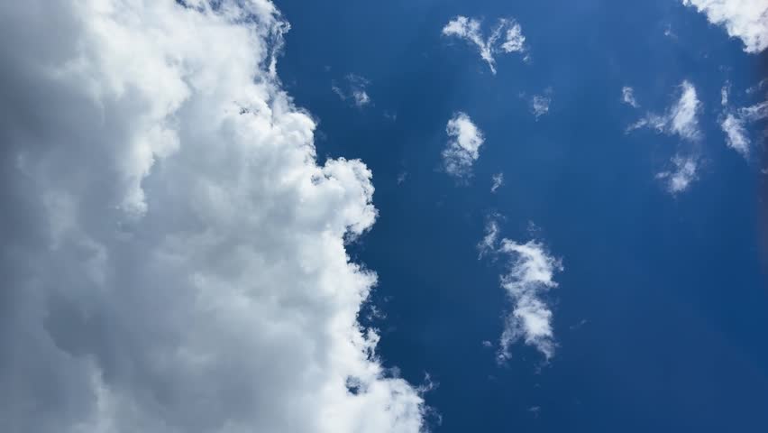 Wide horizontal shot of a large cumulus cloud filling a bright blue sky.