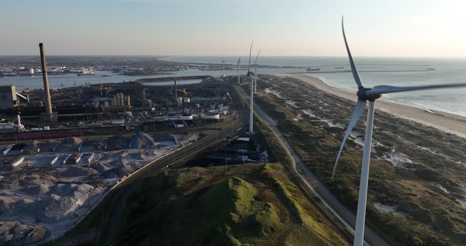 A drone shot of Blast furnaces and wind turbines along the coast in IJmuiden