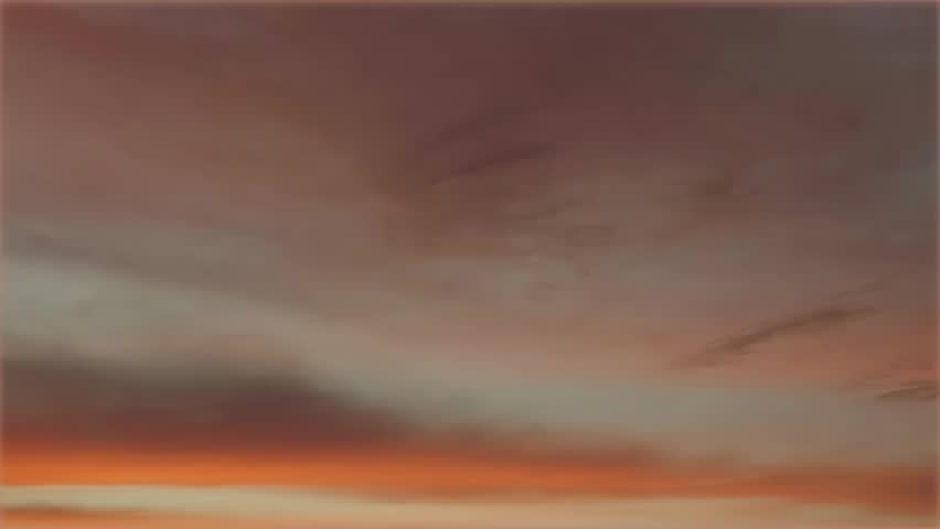 Dramatic sunset sky with soft moving clouds at dusk for background