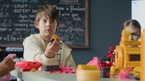 Caucasian boy assembling robotic components during STEM class in school. Footage is suitable for promoting elementary science education and after-school technology programs - Powered by Shutterstock - Get 15% off with code: PIKWIZARD15