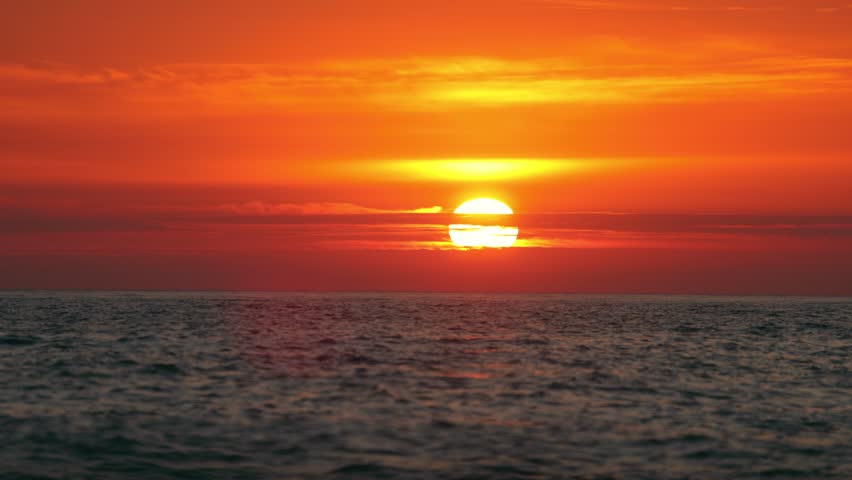 Vibrant orange sunset over the calm sea