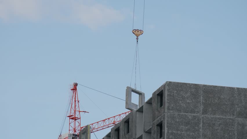 Yellow tower cranes at a construction site of a modern building