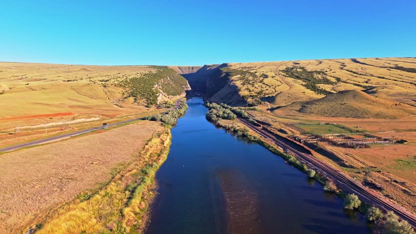 Scenic aerial view of the Bighorn River flowing through Wind River Canyon in Wyoming under a vibrant sunset sky