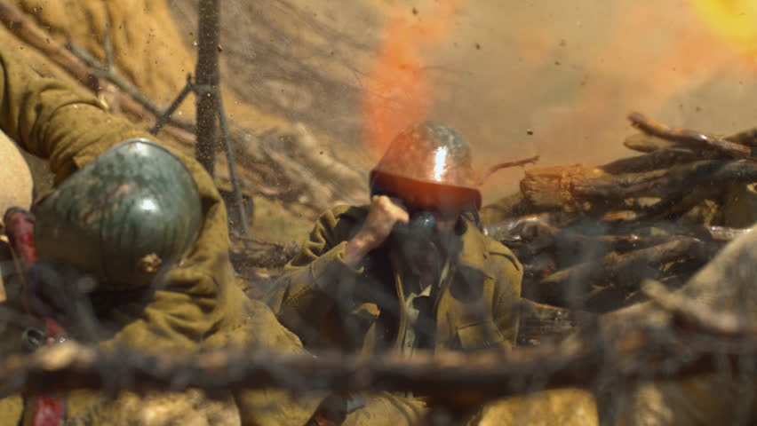 Historical military reenactment showing soldiers take cover in a trench as a blast flashes nearby, captured in ultra slow motion.