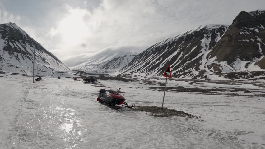 Snowmobile Parked Beside Polar Bear Warning Sign in Svalbard Norway