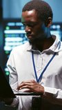 Vertical frame: Computer scientist works inside a data center supporting artificial intelligence, machine learning datasets and large scale computing resources. - Powered by Shutterstock - Get 15% off with code: PIKWIZARD15