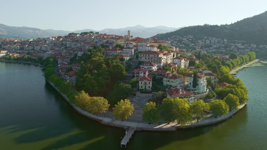 High angle view of the traditional houses and red roofs of Kastoria city during a hazy morning by the lake in Greece