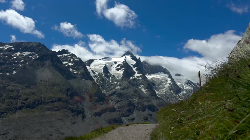Grossglockner Peak with Summer Snow and Slow Moving Clouds in the Austrian Alps. Beautiful horizontal cinematic footage of Grossglockner, Austria